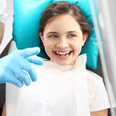 A girl smiling at the camera, representing dental sealants
