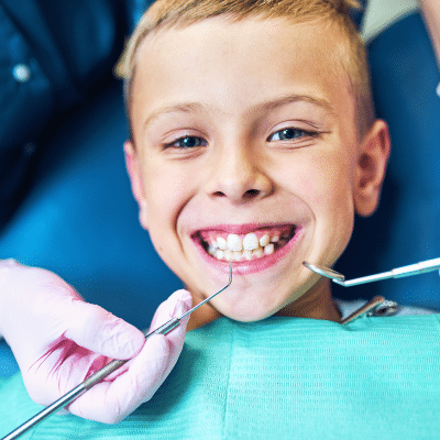 A boy smiling while getting dental treatment, representing dental checkup in santa clarita
