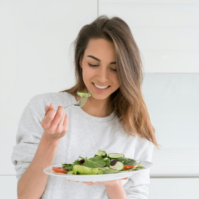 Stevenson ranch 3 Woman smiling while eating a salad, representing role of nutrition in pediatric dental health